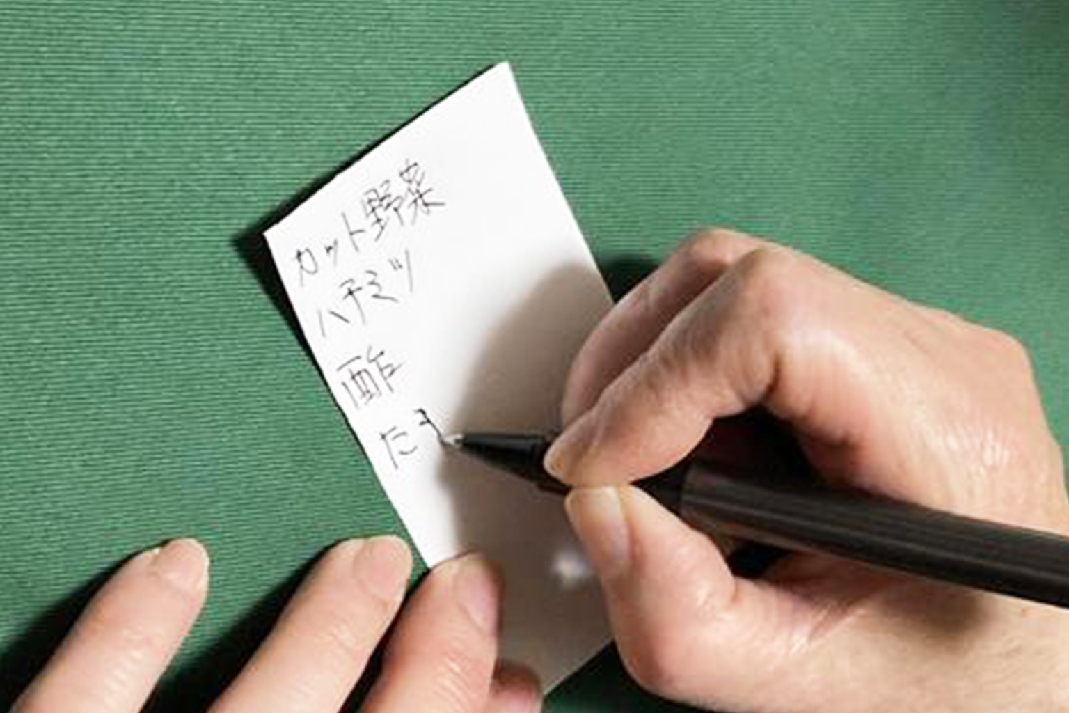 買い物前に節約のためのメモを書く様子